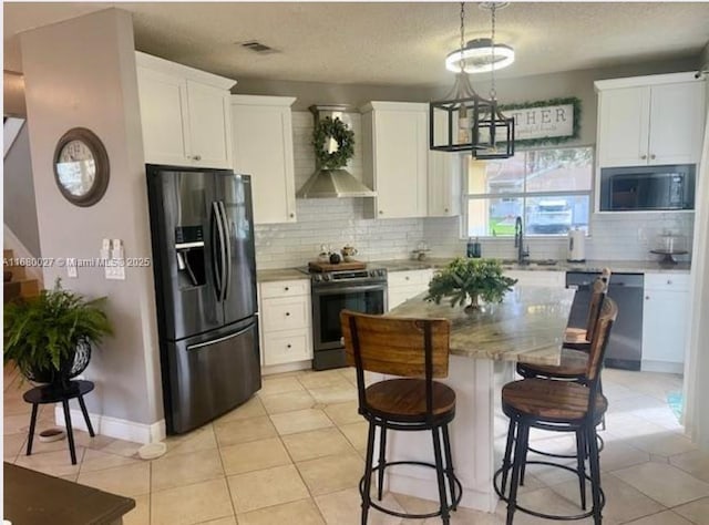 kitchen with light tile patterned floors, white cabinetry, a center island, and stainless steel appliances