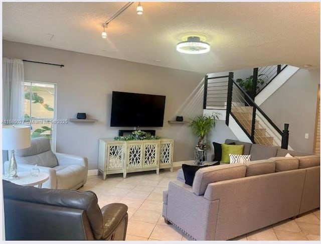 tiled living room featuring a textured ceiling and track lighting