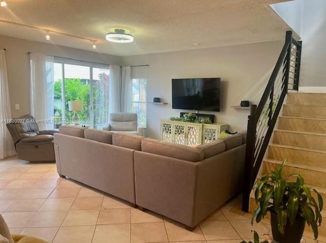 living room featuring a textured ceiling and light tile patterned floors