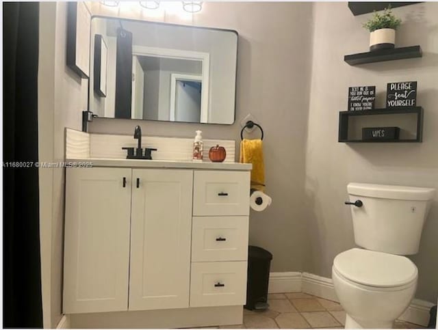 bathroom with vanity, toilet, and tile patterned floors