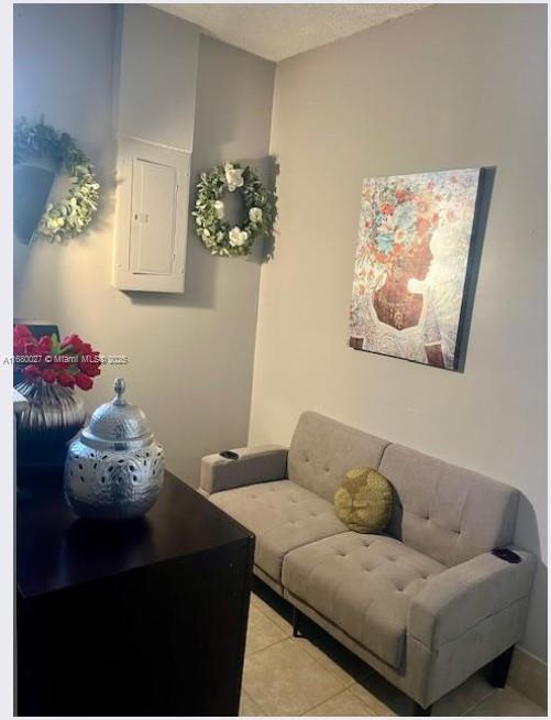 living room with electric panel and light tile patterned floors