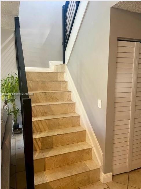 stairway with tile patterned floors