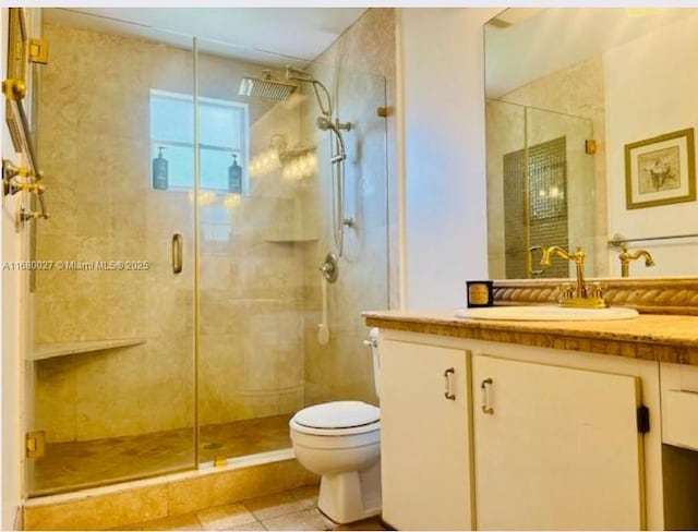 bathroom with tile patterned flooring, toilet, vanity, and walk in shower