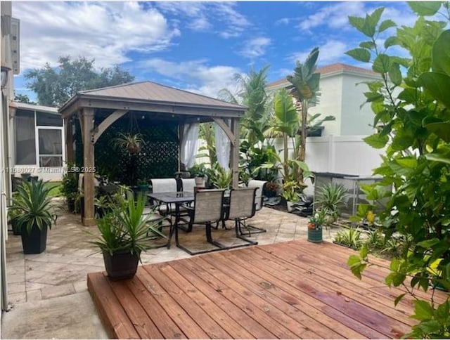 wooden terrace with a sunroom, a gazebo, and a patio