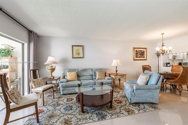 living room with an inviting chandelier, a textured ceiling, and light tile patterned flooring