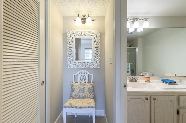 bathroom with a shower with door, toilet, a textured ceiling, and vanity