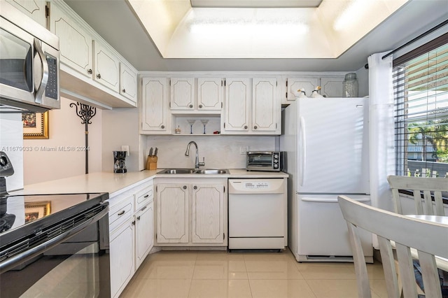 kitchen featuring decorative backsplash, sink, light tile patterned flooring, white cabinetry, and white appliances