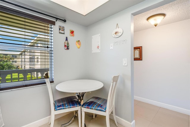 tiled dining room featuring a textured ceiling