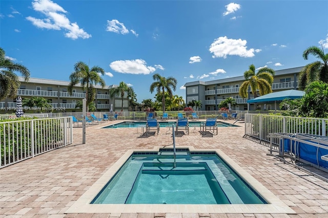 view of swimming pool featuring a patio and a community hot tub