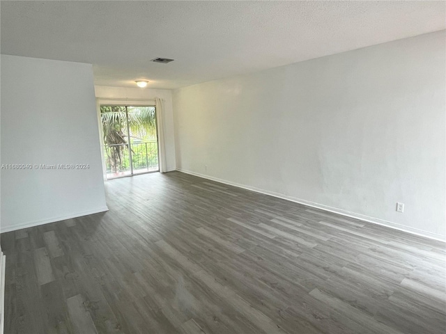 spare room with dark hardwood / wood-style flooring and a textured ceiling