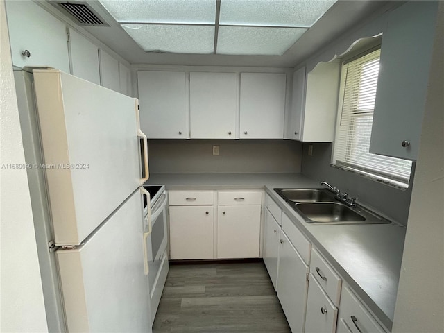 kitchen featuring white appliances, sink, wood-type flooring, and white cabinets