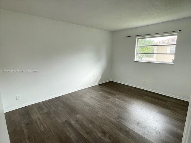 empty room with dark hardwood / wood-style flooring