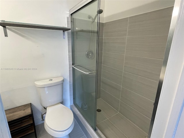 bathroom with toilet and a shower with door