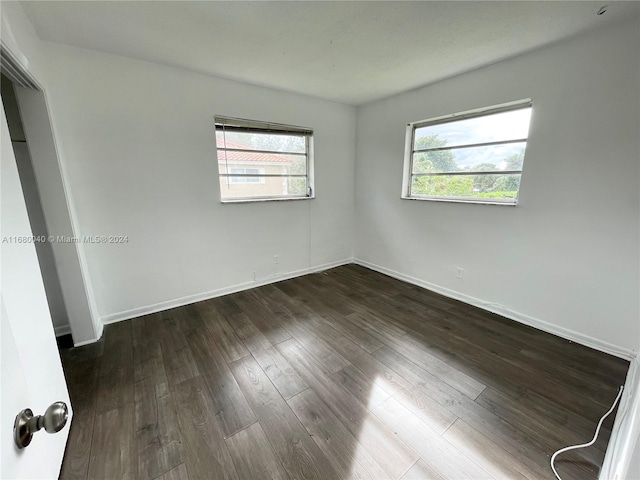 empty room with dark hardwood / wood-style flooring