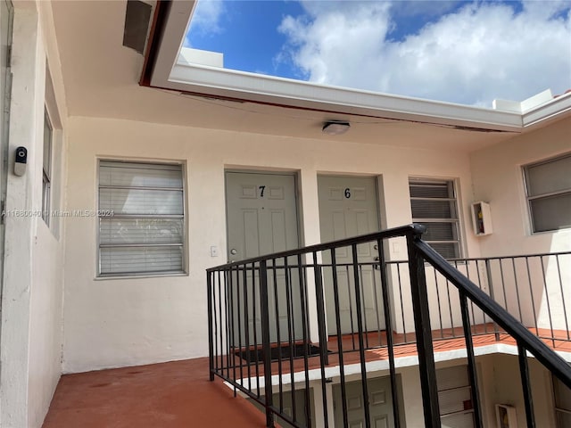 view of exterior entry with a balcony