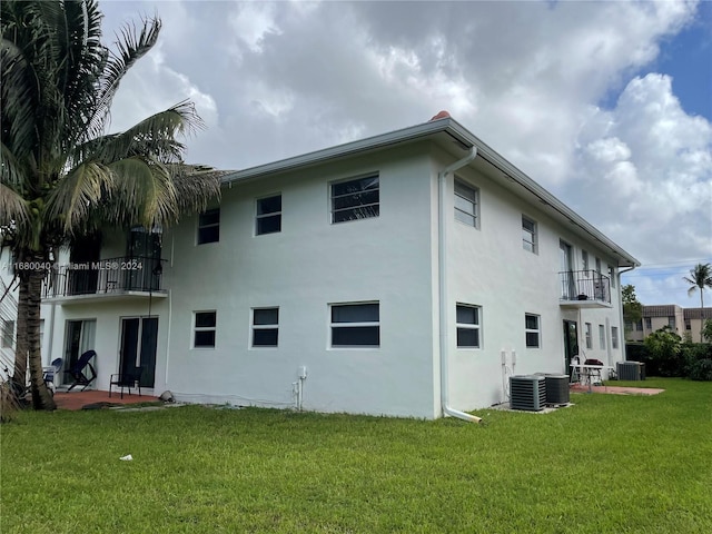 back of house featuring a balcony, a yard, a patio, and cooling unit