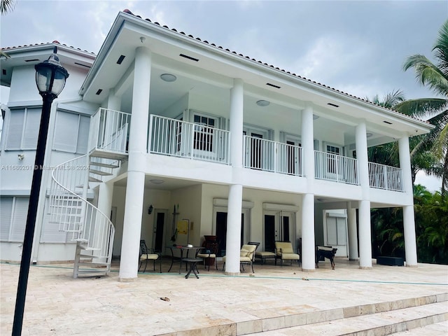 back of property featuring a patio area and a balcony