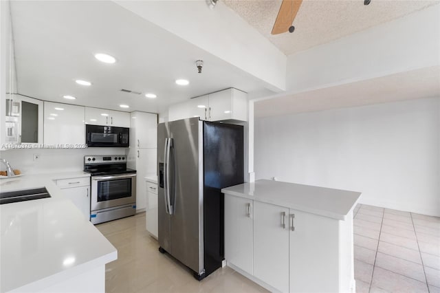 kitchen featuring sink, appliances with stainless steel finishes, a textured ceiling, light tile patterned floors, and white cabinets