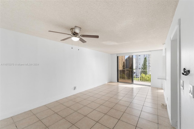 spare room featuring ceiling fan, a textured ceiling, and light tile patterned floors