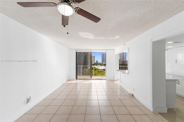 tiled spare room featuring ceiling fan and a textured ceiling