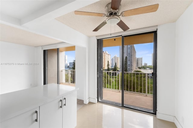 interior space with a textured ceiling, a wall of windows, plenty of natural light, and ceiling fan