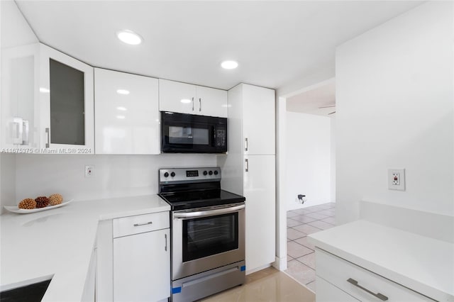 kitchen with white cabinets, light tile patterned floors, and stainless steel range with electric cooktop