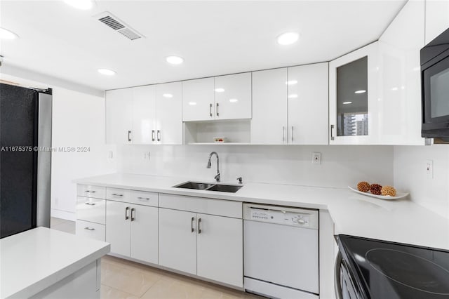 kitchen with black appliances, sink, light tile patterned floors, and white cabinets