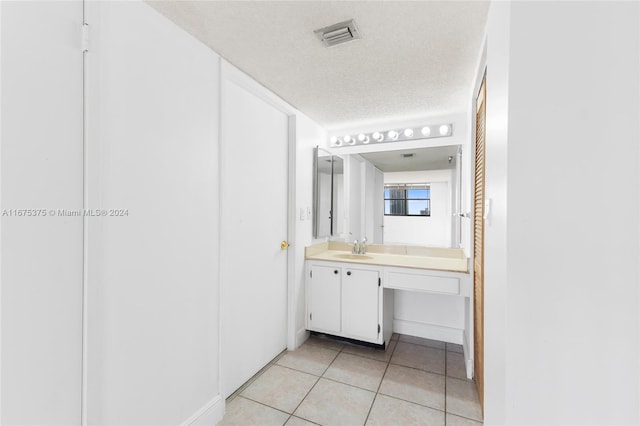 bathroom with vanity, a textured ceiling, and tile patterned floors