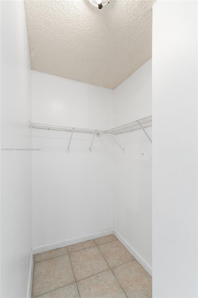 walk in closet with light tile patterned floors