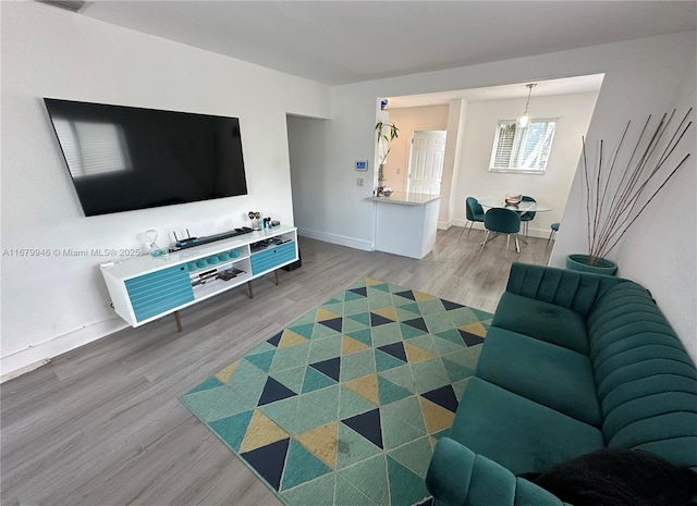 living area featuring visible vents, baseboards, and wood finished floors