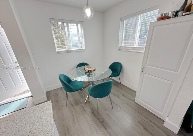 dining room featuring light wood-style floors and baseboards