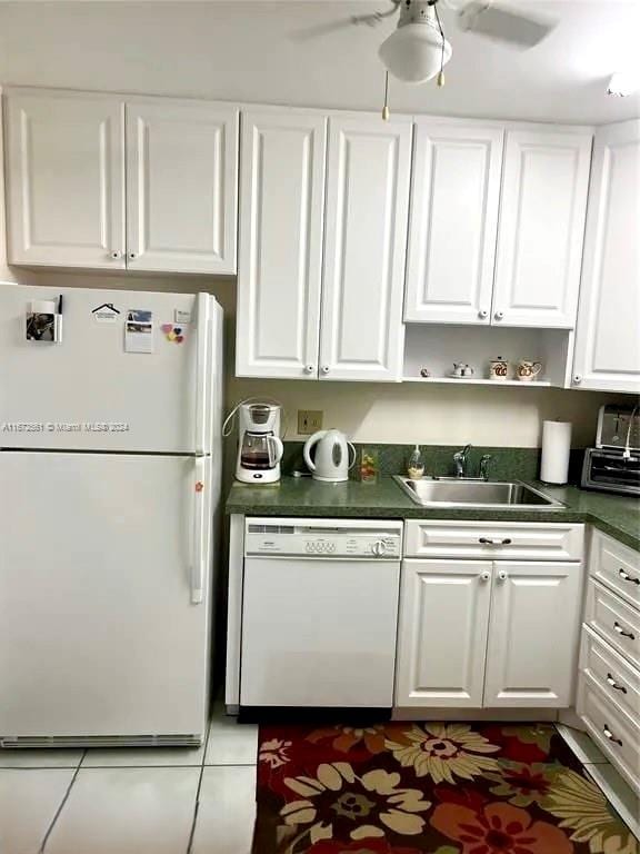 kitchen with white cabinets, ceiling fan, sink, tile patterned floors, and white appliances