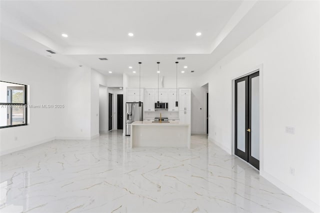 unfurnished living room with a tray ceiling