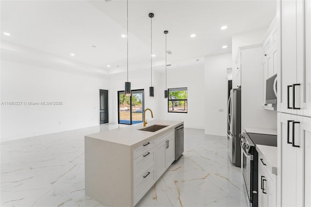 kitchen with sink, a center island with sink, pendant lighting, stainless steel appliances, and white cabinets