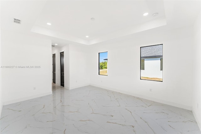 empty room featuring a raised ceiling