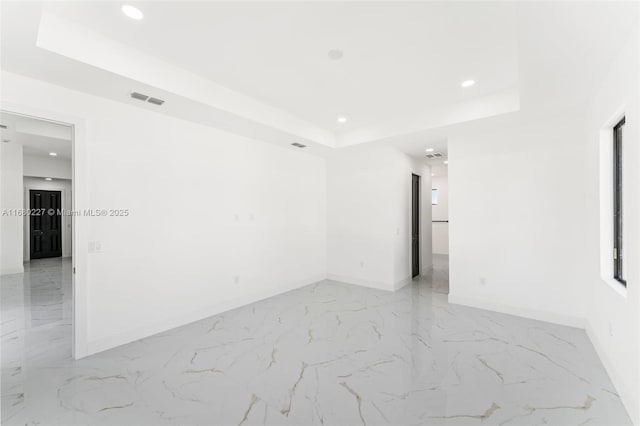 spare room featuring a raised ceiling