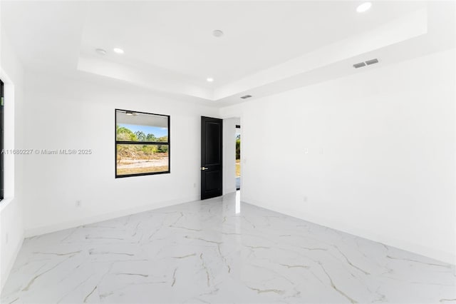 unfurnished room with a raised ceiling