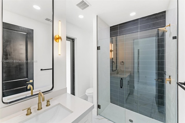 bathroom featuring vanity, a shower with door, and toilet