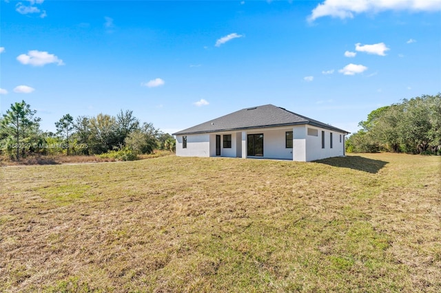 rear view of property with a yard