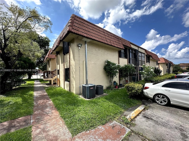 view of home's exterior featuring central AC and a lawn