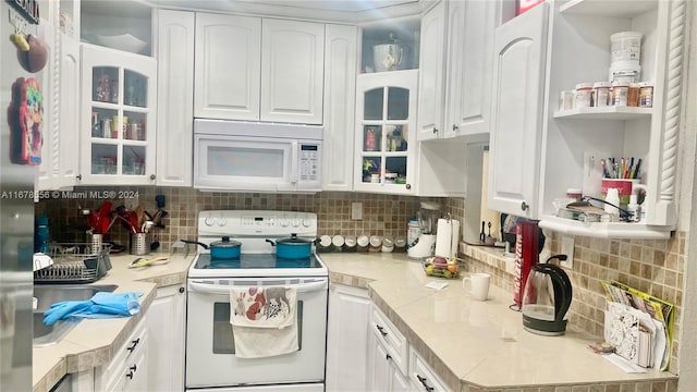 kitchen featuring white cabinetry, white appliances, and tasteful backsplash