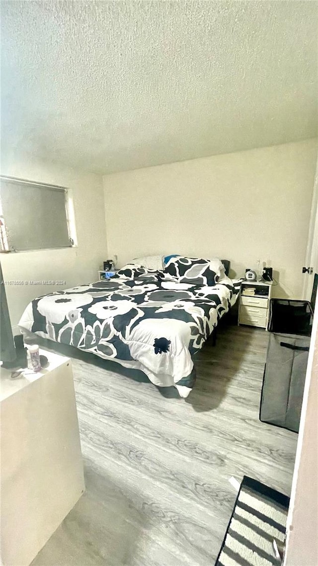 bedroom with light hardwood / wood-style flooring and a textured ceiling