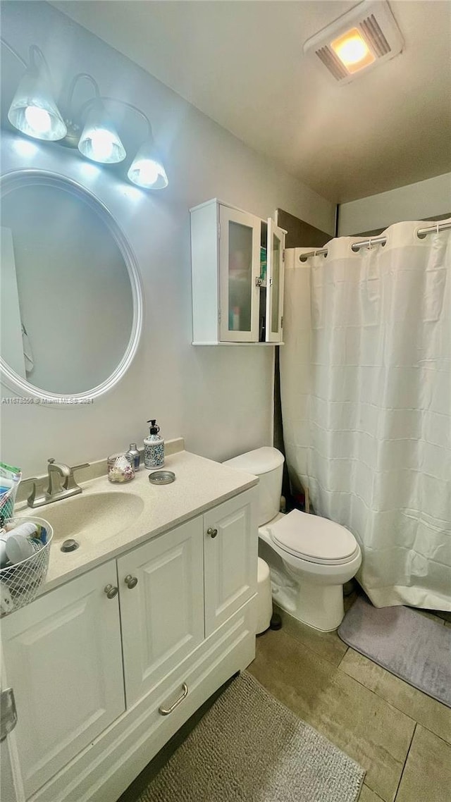 bathroom featuring vanity, a shower with curtain, toilet, and tile patterned flooring