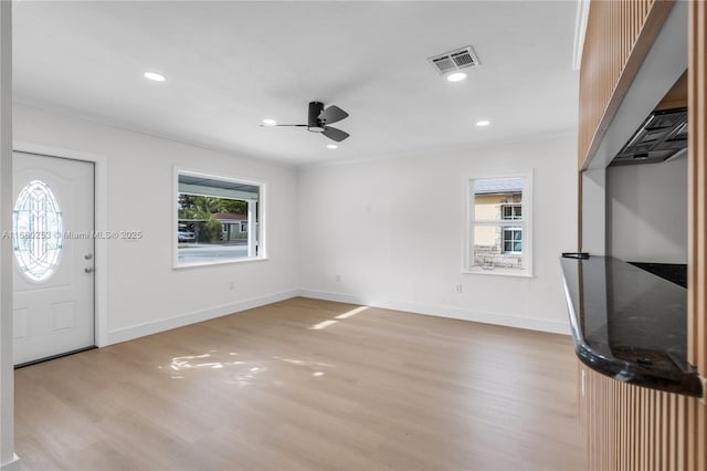 foyer entrance featuring light wood-style floors, visible vents, and a wealth of natural light