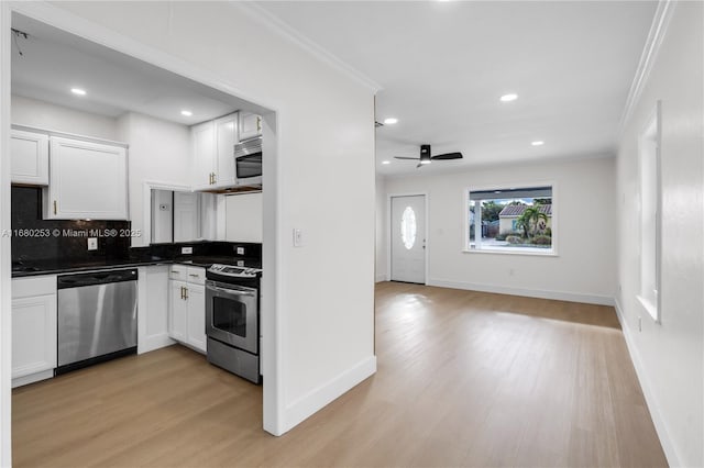 kitchen with light hardwood / wood-style floors, white cabinets, backsplash, and appliances with stainless steel finishes