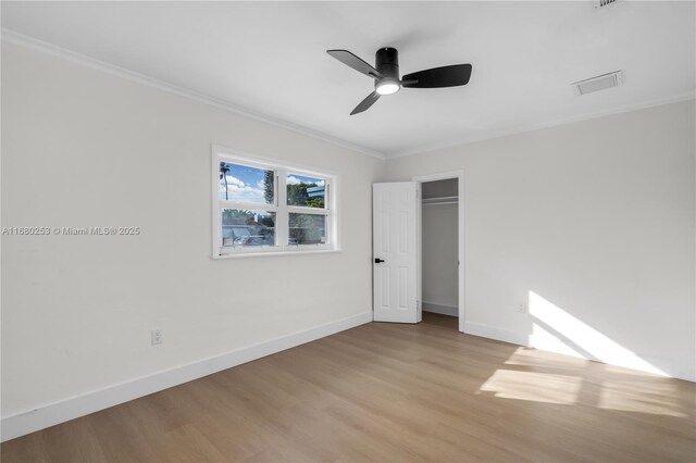 unfurnished bedroom featuring ceiling fan, light hardwood / wood-style flooring, and crown molding