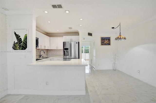 kitchen featuring kitchen peninsula, stainless steel appliances, decorative light fixtures, white cabinets, and decorative backsplash