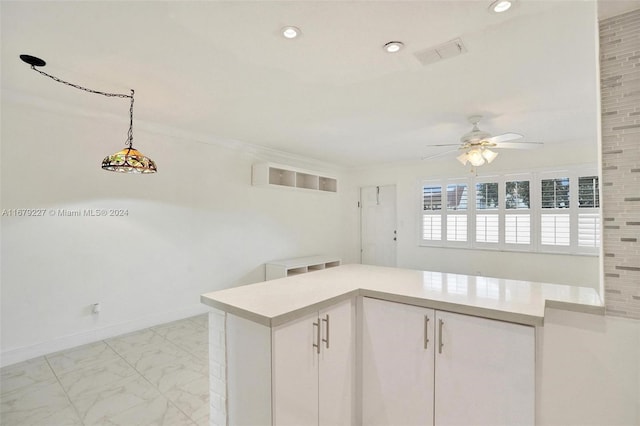 kitchen with ceiling fan, hanging light fixtures, and white cabinets