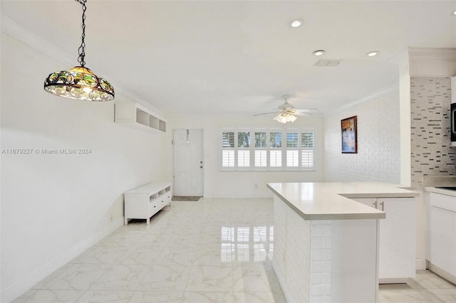 kitchen with white cabinetry, ceiling fan, ornamental molding, and decorative light fixtures