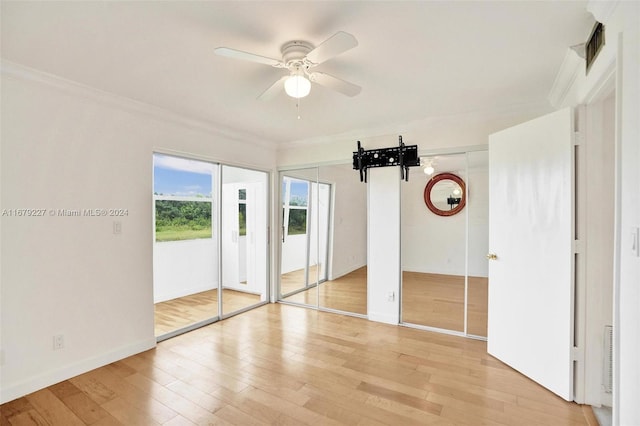 interior space with light hardwood / wood-style floors, crown molding, two closets, and ceiling fan